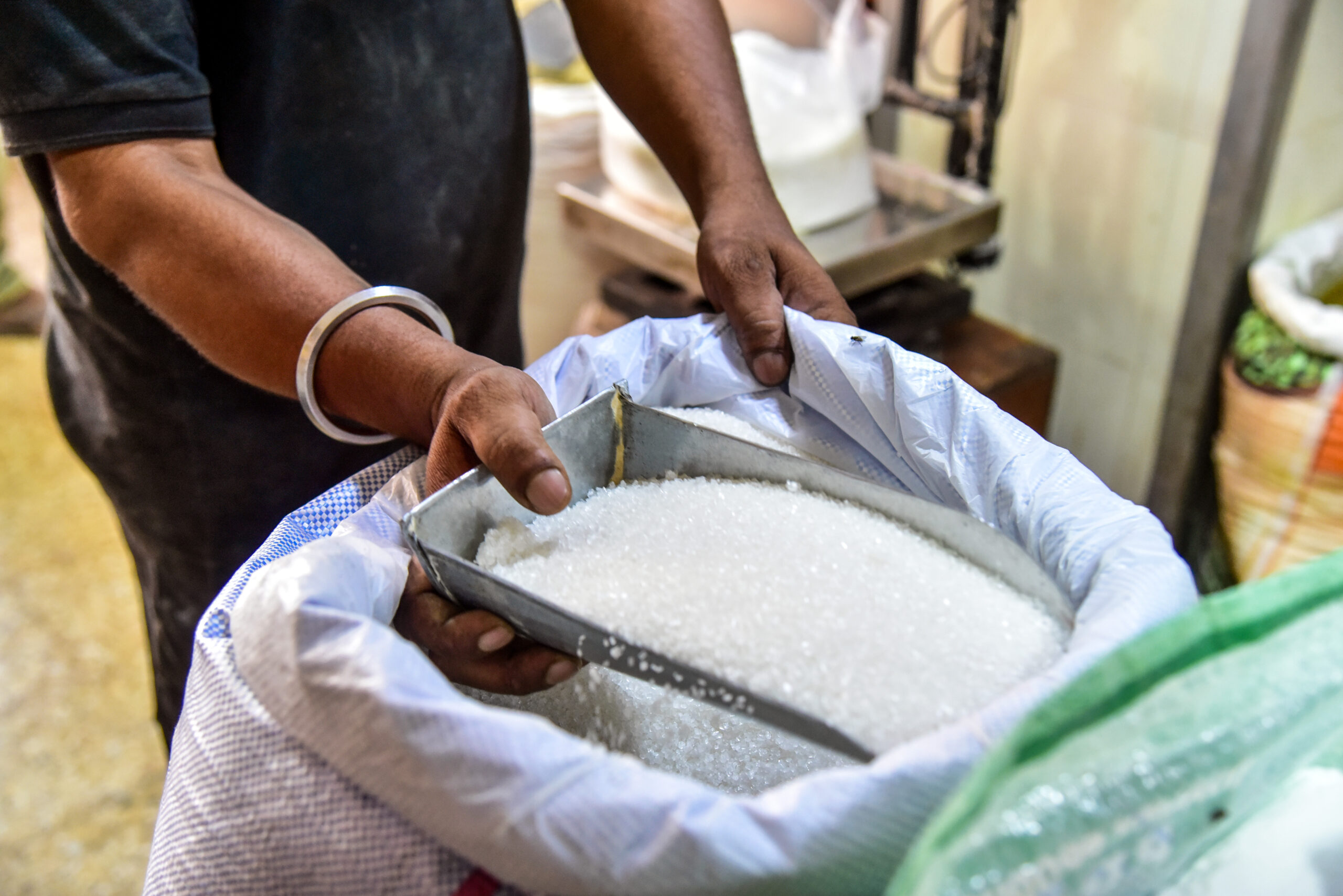 Bikaner: A shopkeeper weighs sugar for a customer at his store amid rising sugar prices in Bikaner, Rajasthan, on Sunday, August 23, 2026. (Photo: IANS)