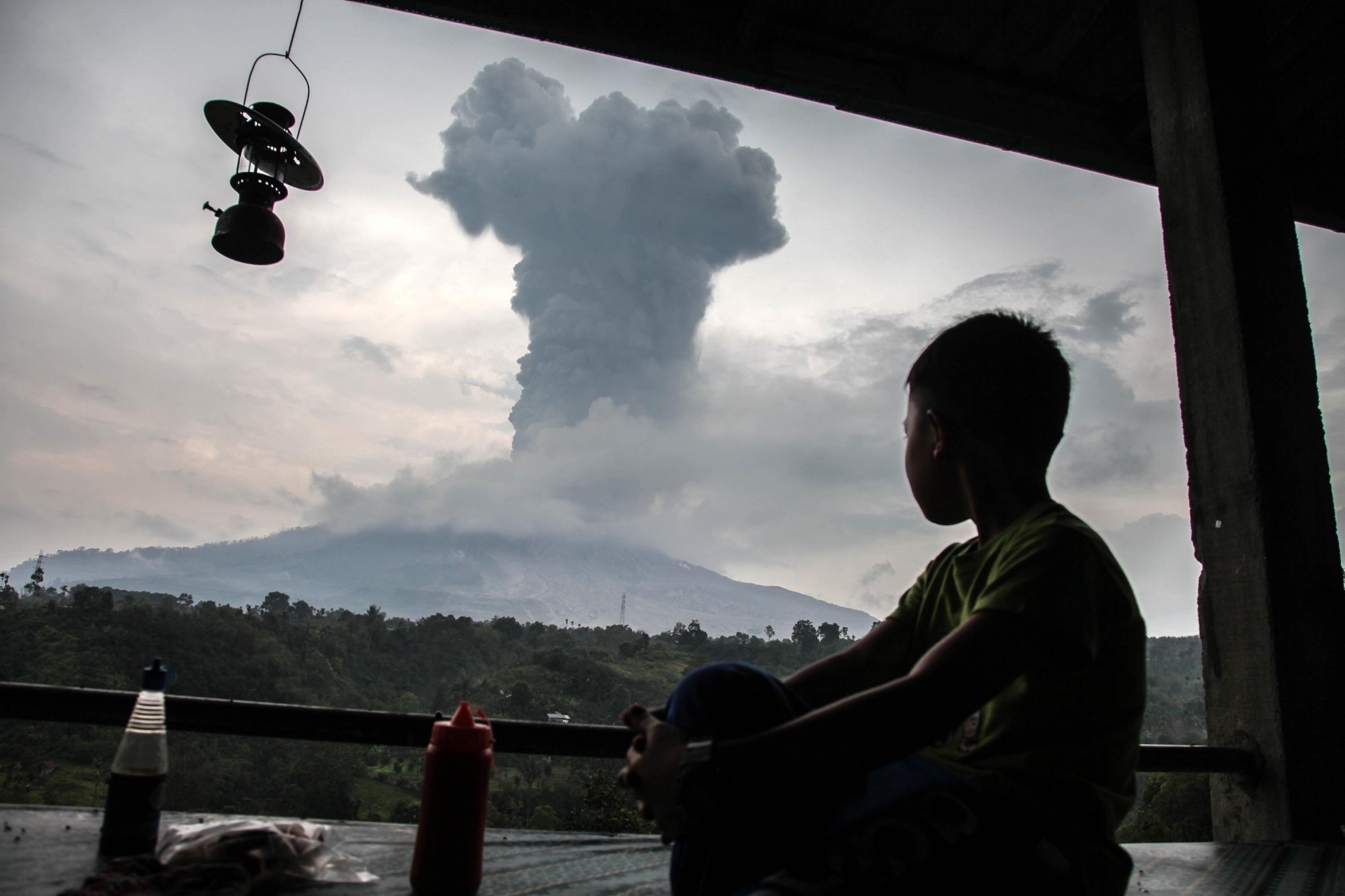 NORTH SUMATRA (INDONESIA), April 19, 2018 (Xinhua) -- A boy watches the Mount Sinabung volcano spewing volcanic ash in Karo, North Sumatra, Indonesia, on April 19, 2018. (Xinhua/Alberth Damanik/IANS)