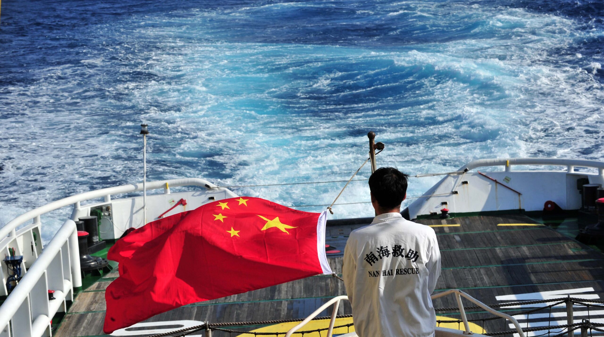 (140318) -- "SOUTH CHINA SEA RESCUE 101", March 18, 2014 (Xinhua) -- Sailor Li Guodong of the "South China Sea Rescue 101" raises the Chinese national flag on the vessel, March 18, 2014. Chinese rescue vessels which were on standby at the gulf of Thailand have set sail towards the rally point in Singapore for further rescue. (Xinhua/Zhao Yingquan)