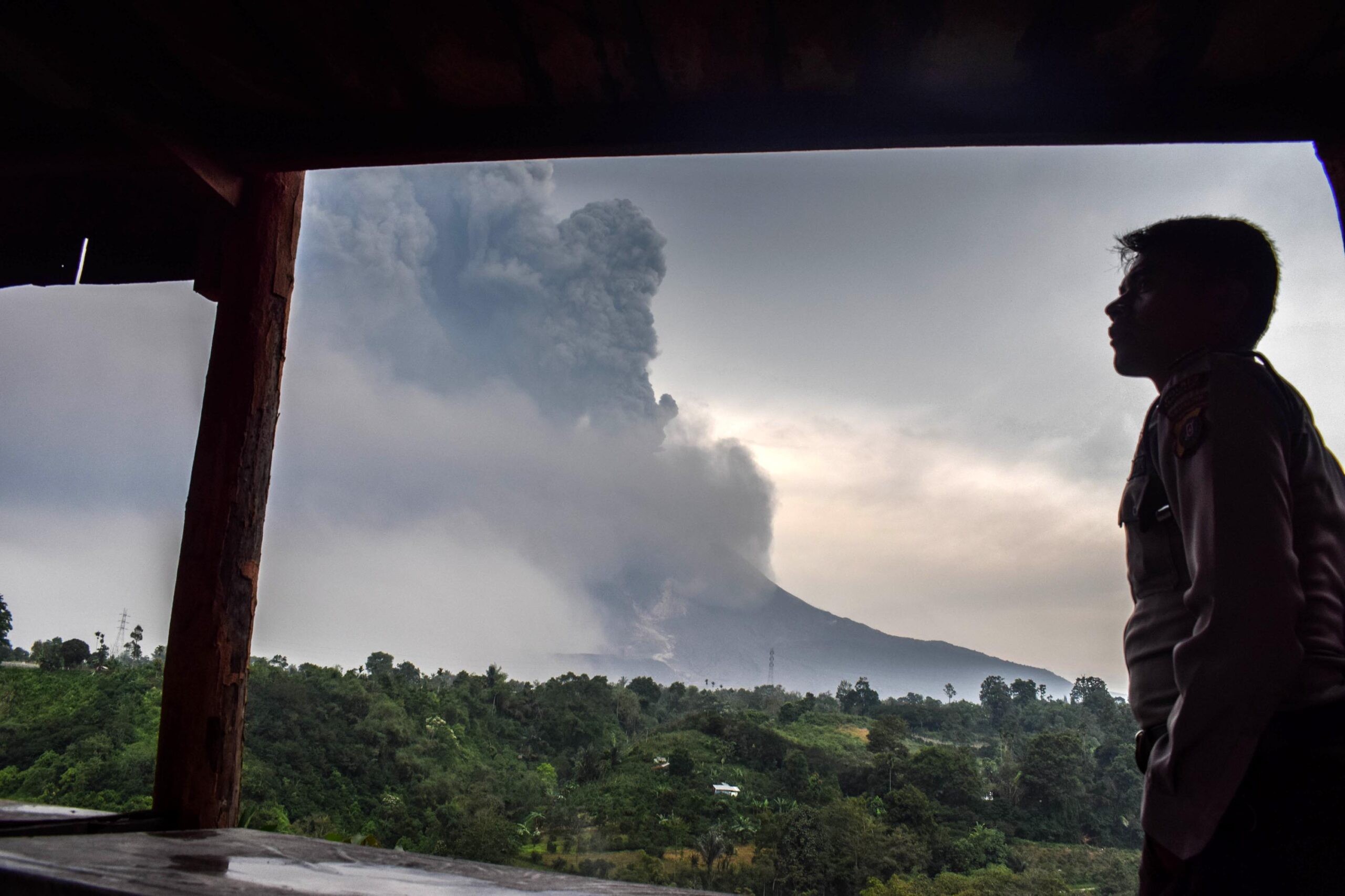 (180407) -- NORTH SUMATERA, April 7, 2018 (Xinhua) -- A man watches Mount Sinabung volcano spewing thick volcanic ash, seen from the town of Karo, North Sumatera, Indonesia, on April 6, 2018. (Xinhua/Sarianto) (zxj)