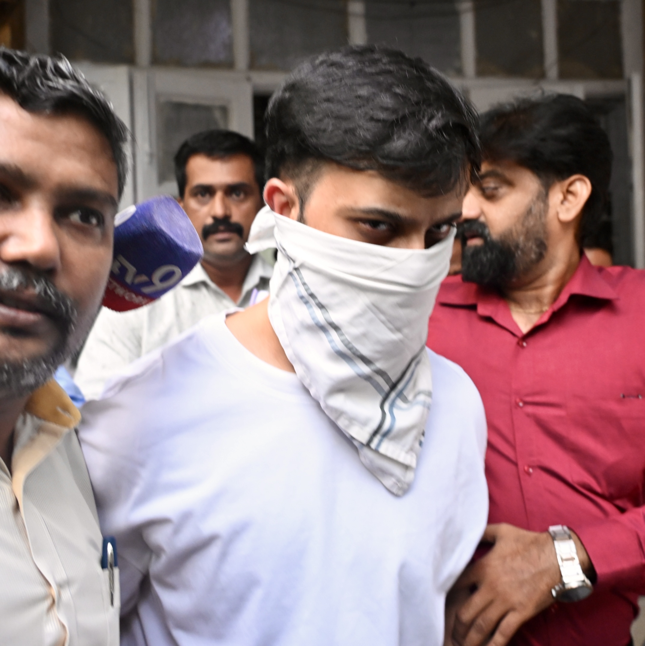 Mumbai: Police officials arrest Rohan Parekh, a 24-year-old man wearing a white mask, after he allegedly posed as a PMO official and attempted to forcibly enter a shopping mall in Bandra-Kurla Complex (BKC) while carrying a firearm, in Mumbai, on Tuesday, September 8, 2026. (IANS)