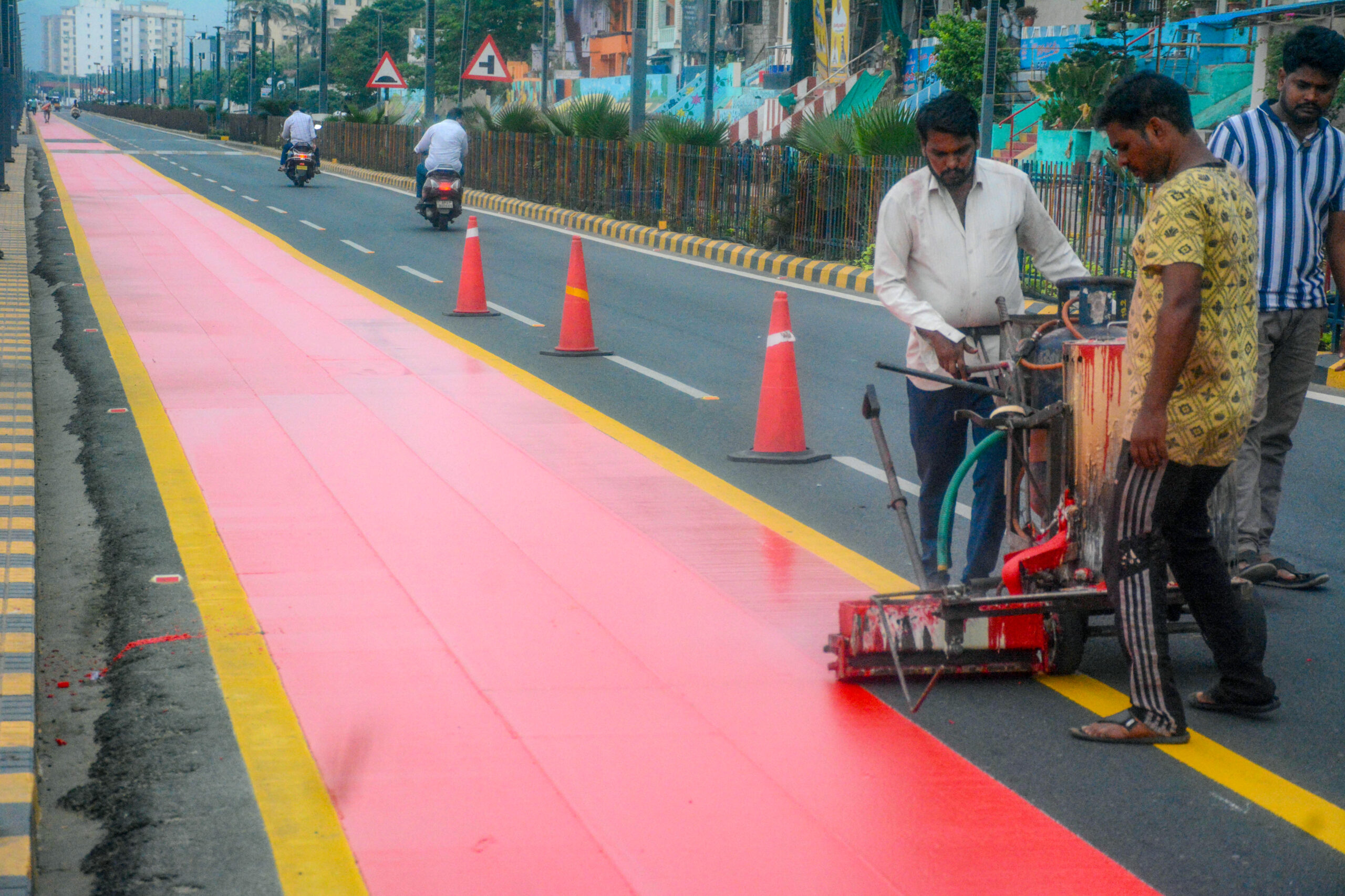 Visakhapatnam: Workers apply red coating to create a new cycle track along RK Beach Road in Visakhapatnam on Thursday, September 10, 2026. (Photo: IANS)