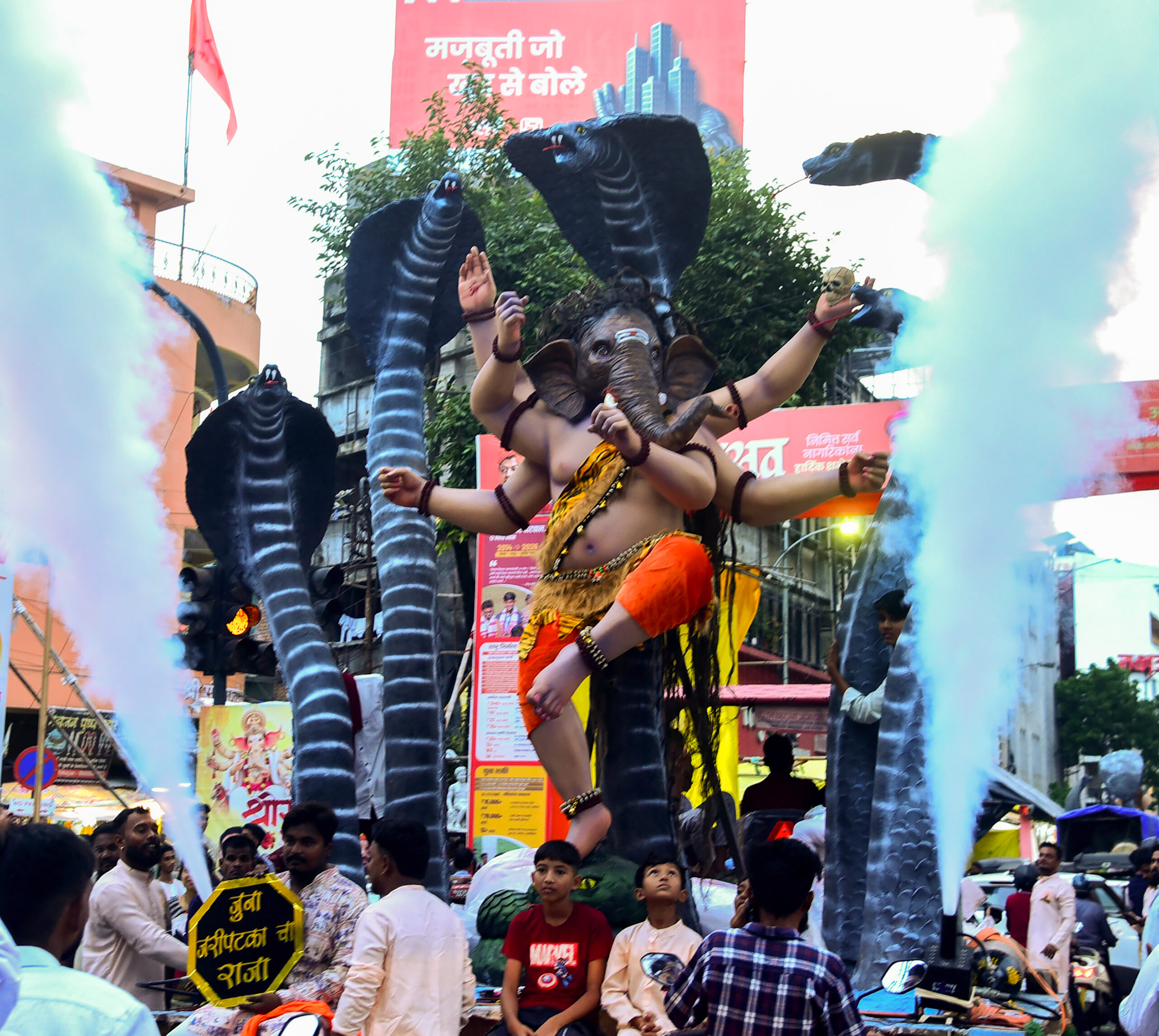 Nagpur: Devotees transport a massive idol of Lord Ganesha to a pandal ahead of the Ganesh Chaturthi festival, in Nagpur on Sunday, September 13, 2026. (Photo: IANS)