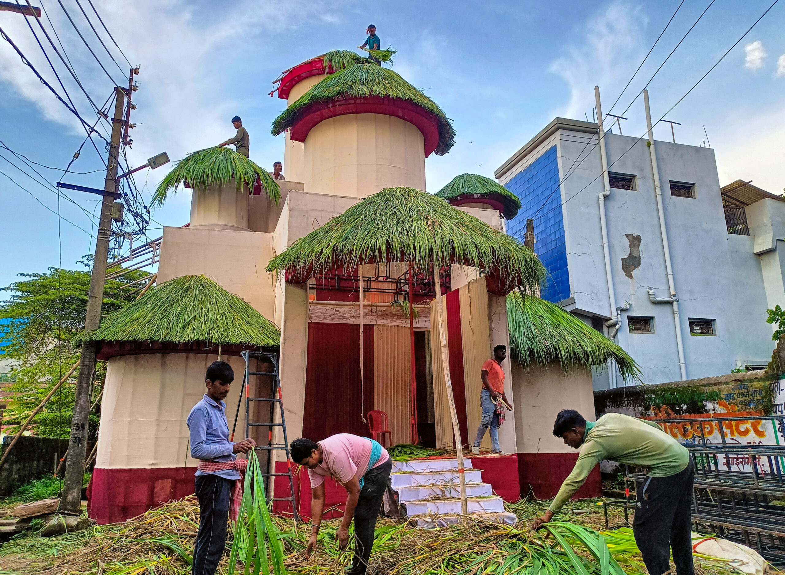 Jagdalpur: Artisans give finishing touches to hut themed Ganesh pandal #Gallery Jagdalpur: Artisans give finishing touches to hut themed Ganesh pandal #Gallery