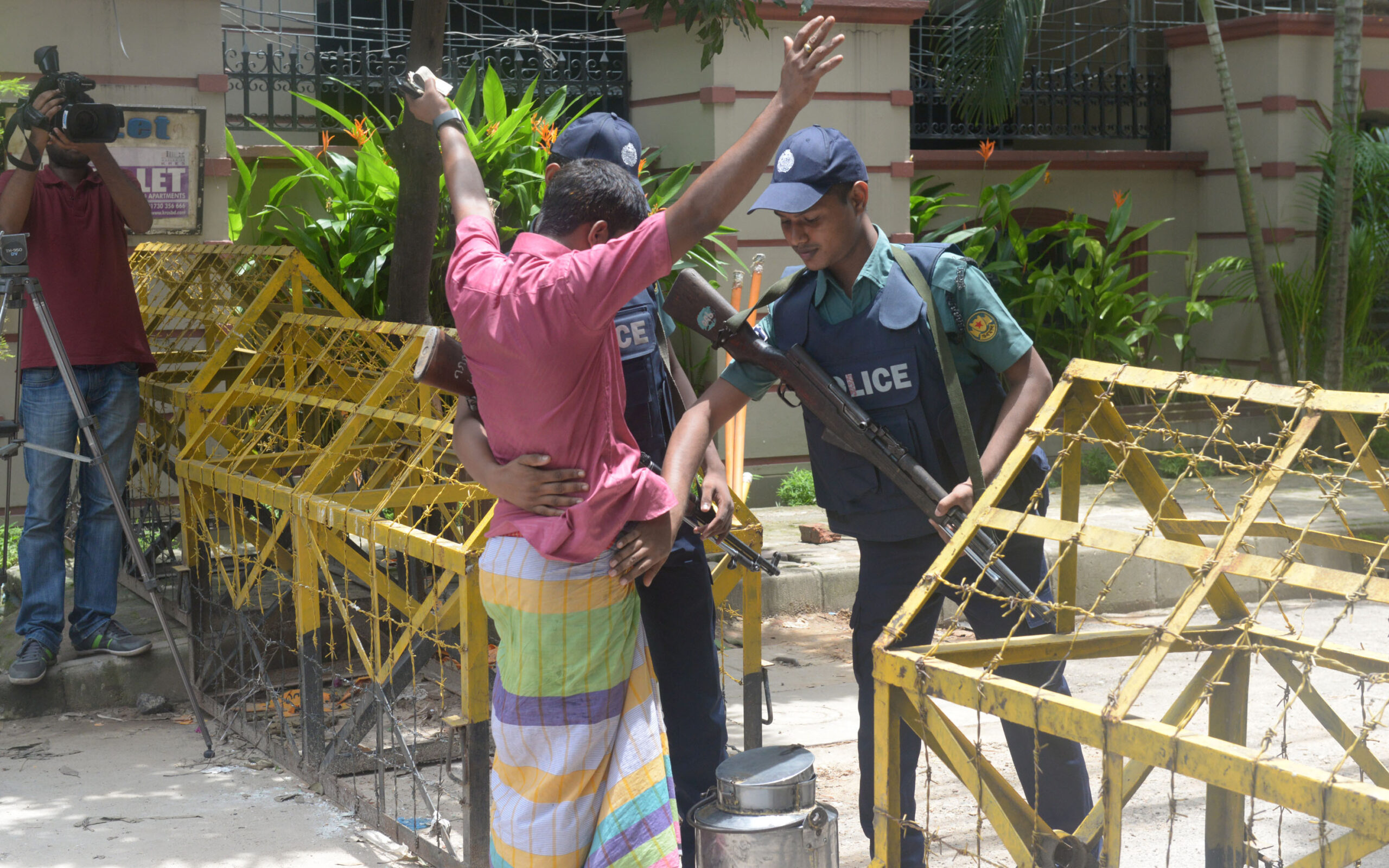 (160710) -- DHAKA, July 10, 2016 (Xinhua) -- Bangladeshi policemen frisk a man near the Spanish restaurant where the militant attack took place in Dhaka, Bangladesh, July 10, 2016. After a video where three Bangla-speaking men are seen commending Dhaka's cafe attackers and threatening more attacks in Bangladesh went viral on social media, Bangladesh police has warned of stern action against those sharing any such content which indulges militant activity. (Xinhua/Shariful Islam)