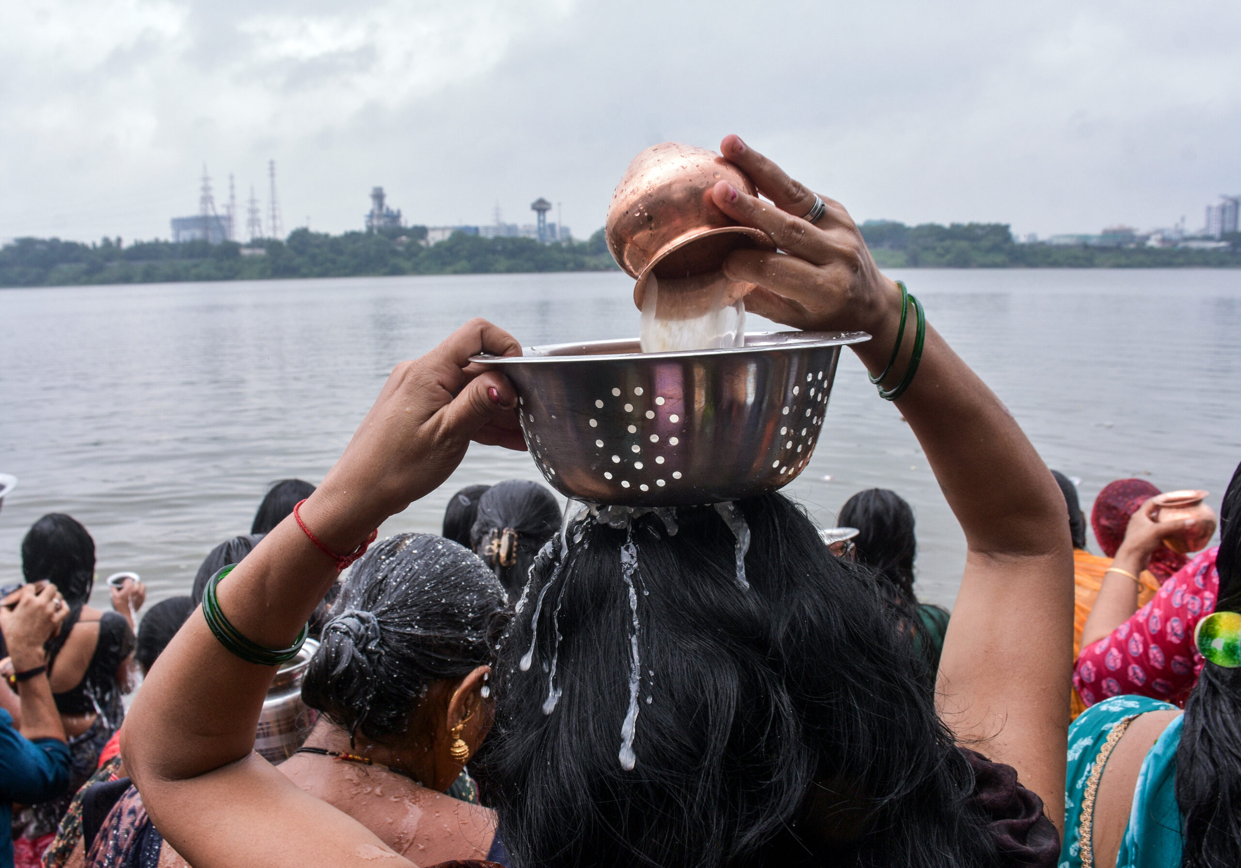 Surat: A woman devotee pours water over her head while performing rituals at the confluence of the Tapi River on Rishi Panchami, in Surat on Tuesday, September 15, 2026. (Photo: IANS)