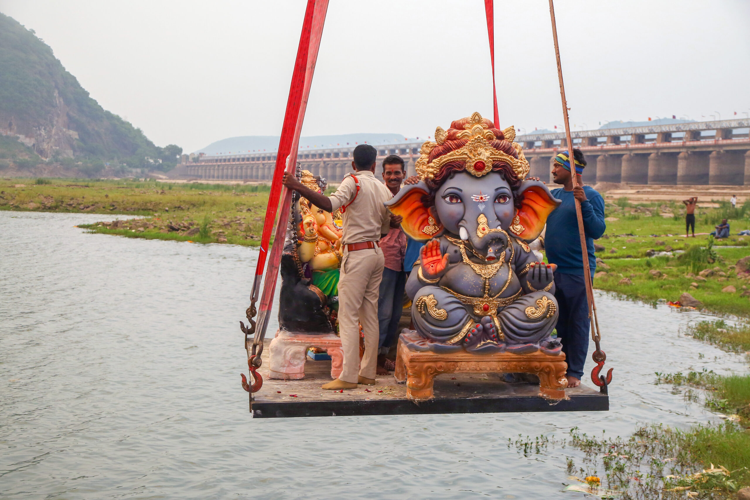 Vijayawada: Devotees transport Ganesh idols suspended from a crane over the Krishna River for immersion downstream of Prakasam Barrage during Ganesh Chaturthi celebrations in Vijayawada on Wednesday, September 16, 2026. (Photo: IANS)