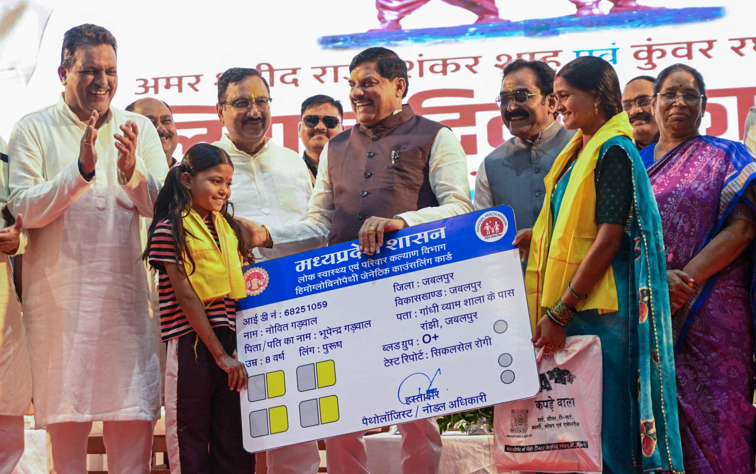 Jabalpur: Madhya Pradesh Chief Minister Mohan Yadav presents a Public Health and Family Welfare Department card to a woman and child during a programme marking the martyrdom day of Raja Shankar Shah and Kunwar Raghunath Shah, in Jabalpur, Madhya Pradesh, on Friday, September 18, 2026. (Photo: IANS)