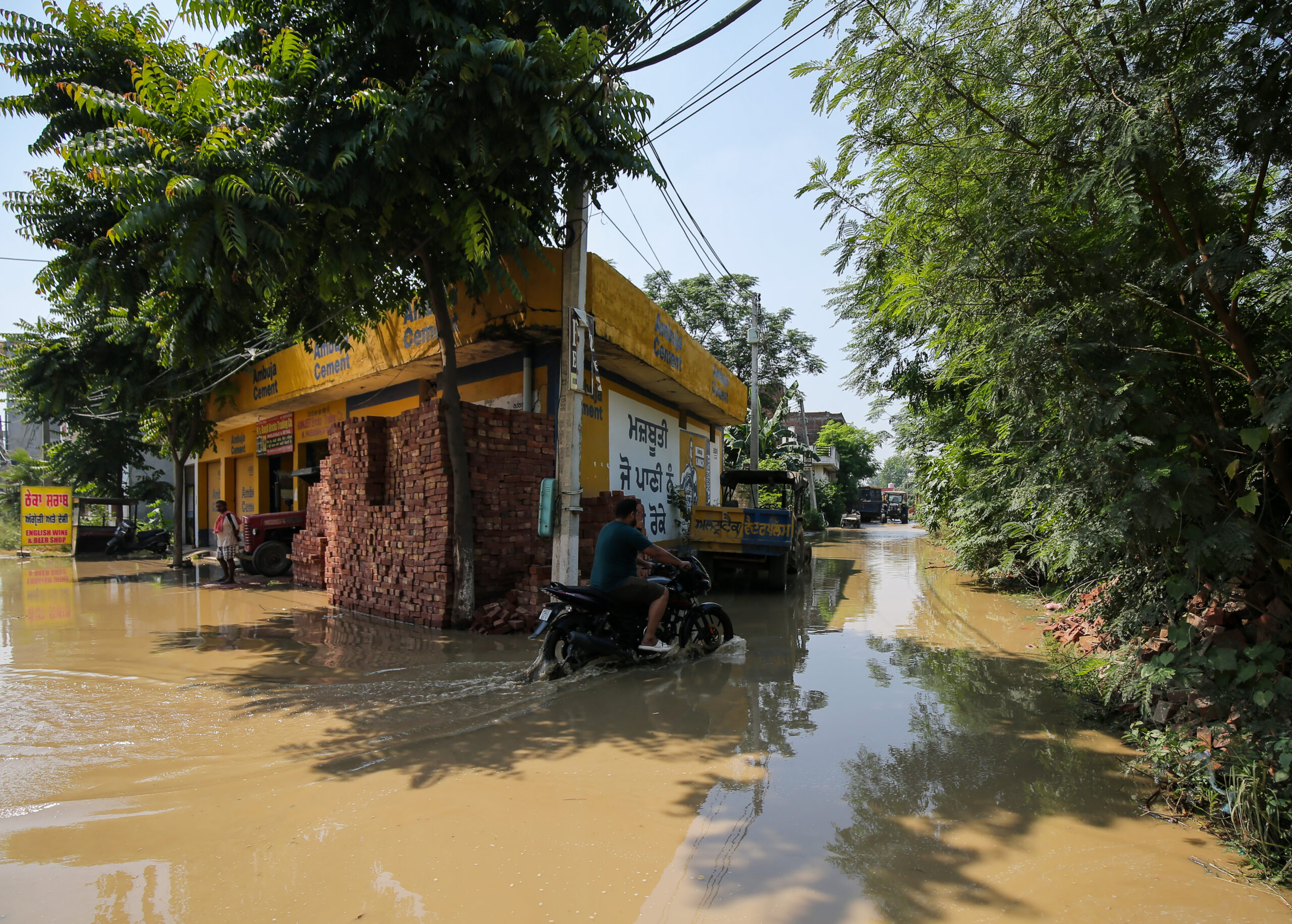 Amritsar: A motorcyclist navigates through water after a breach in the Upper Bari Doab Canal (UBDC) inundates residential areas in Amritsar on Saturday, September 19, 2026. (Photo: IANS)
