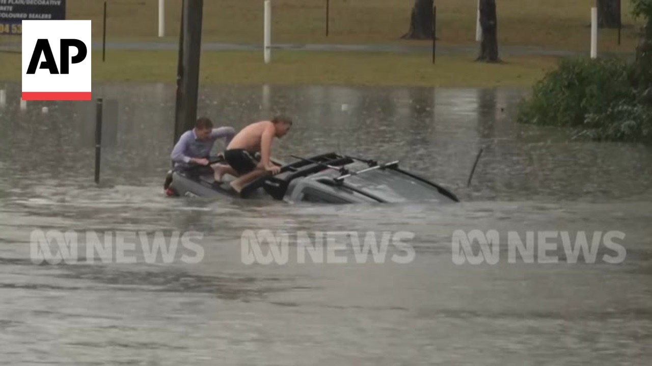 Australian reporter and another bystander rescue a driver from a sinking car (Video)